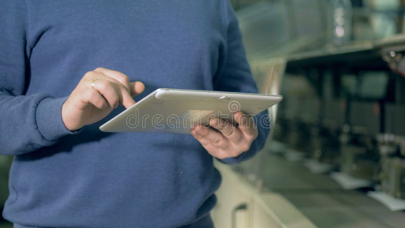 Человек печатает на планшете на офисе печати, конце вверх